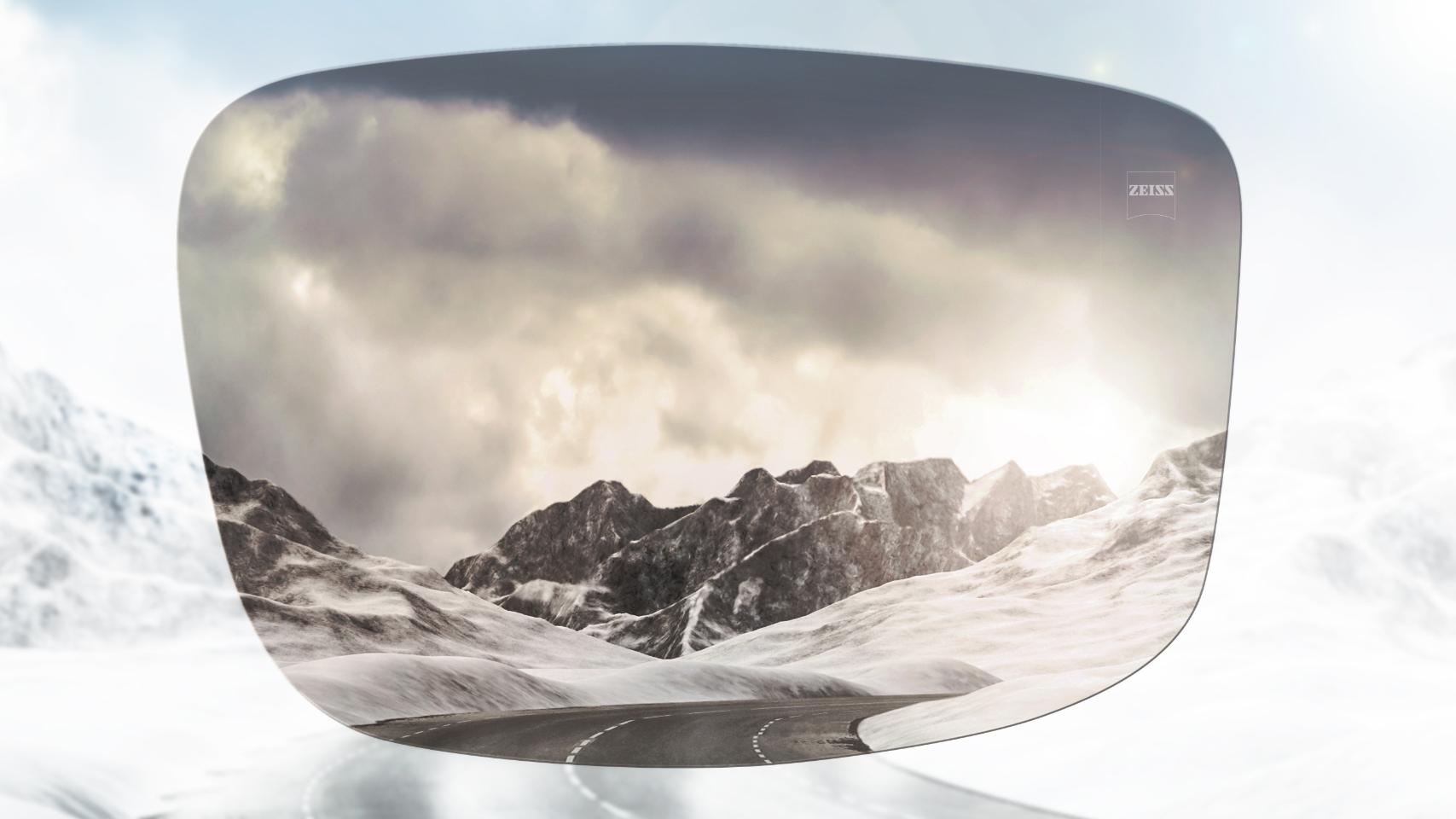 Comparação de uma estrada de montanha com neve com e sem óculos polarizados. Os óculos de sol polarizados reduzem o encandeamento e facilitam a visão em frente.